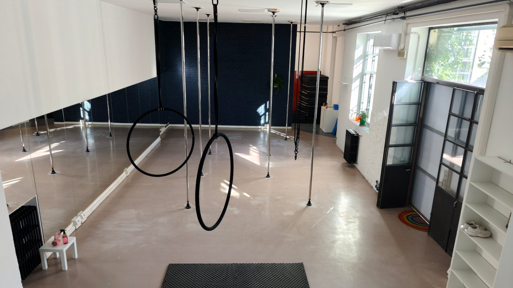 La sala di Paradise Studio: pali, cerchi aerei, specchi e grandi finestre